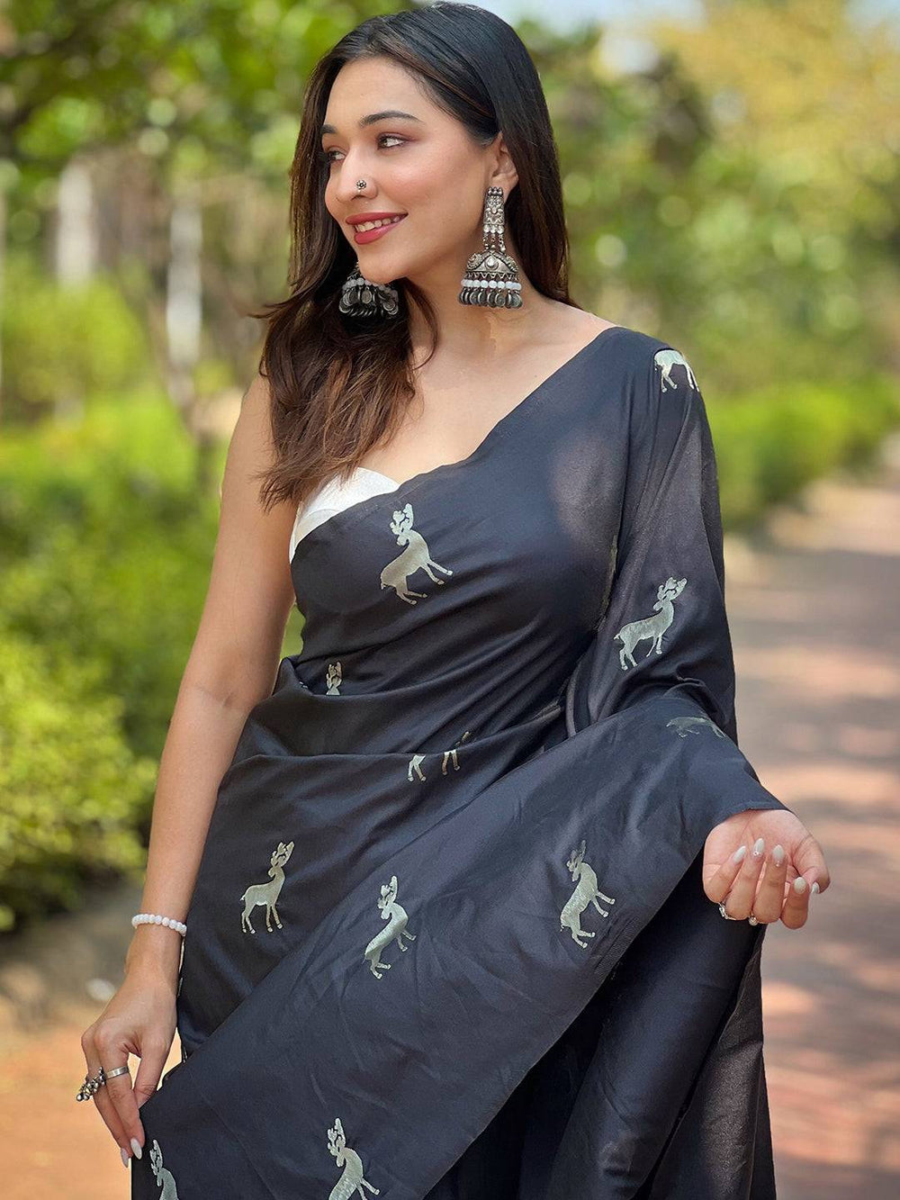 Woman in black soft silk saree with zari pallu outdoors