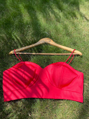 Red sleeveless blouse on hanger