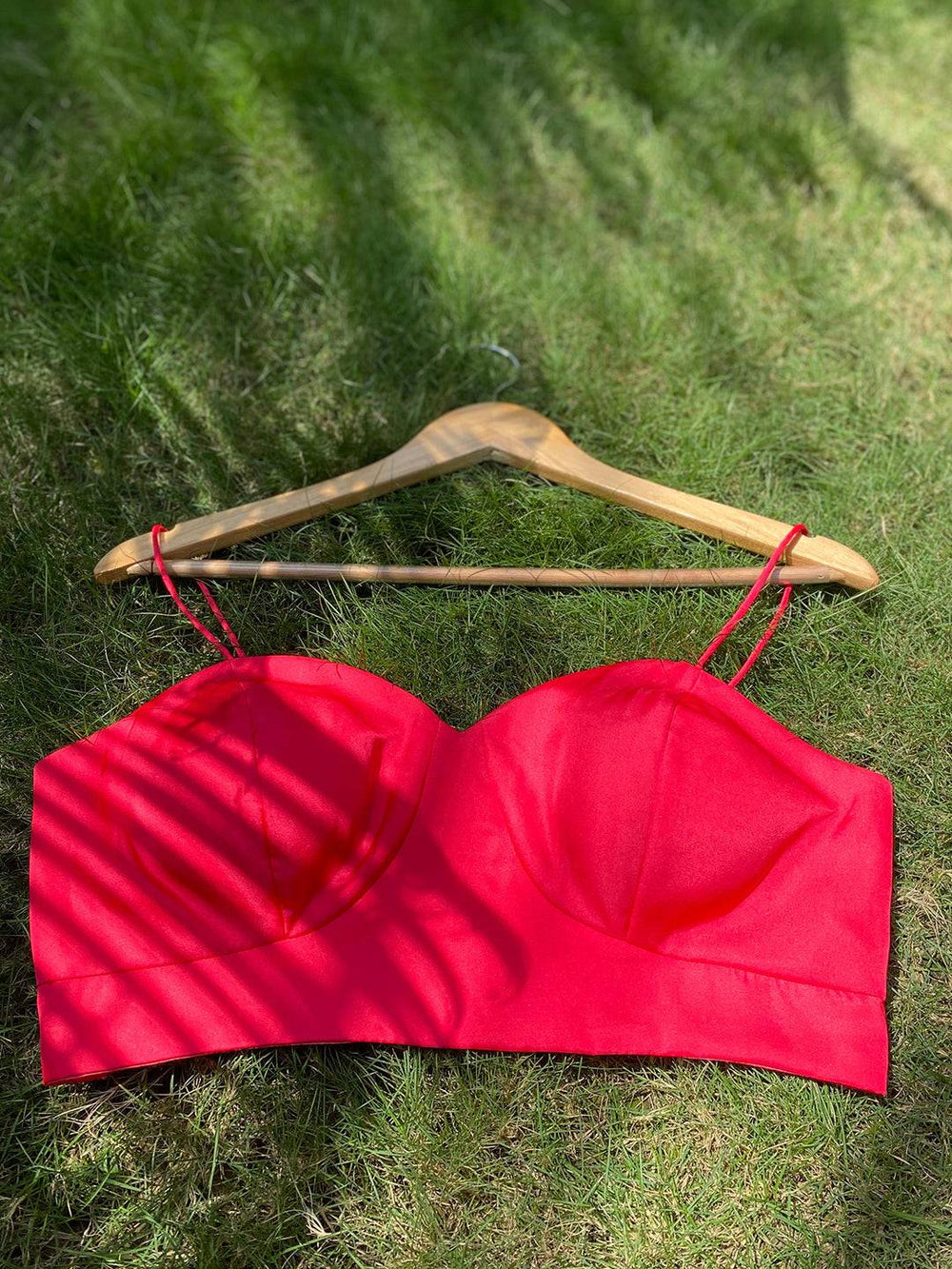 Red sleeveless blouse on hanger