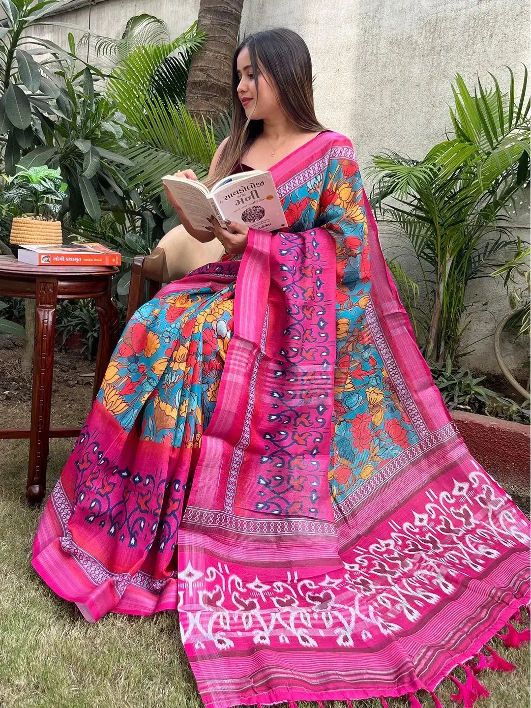 Woman reading in floral Ikkat printed party wear saree