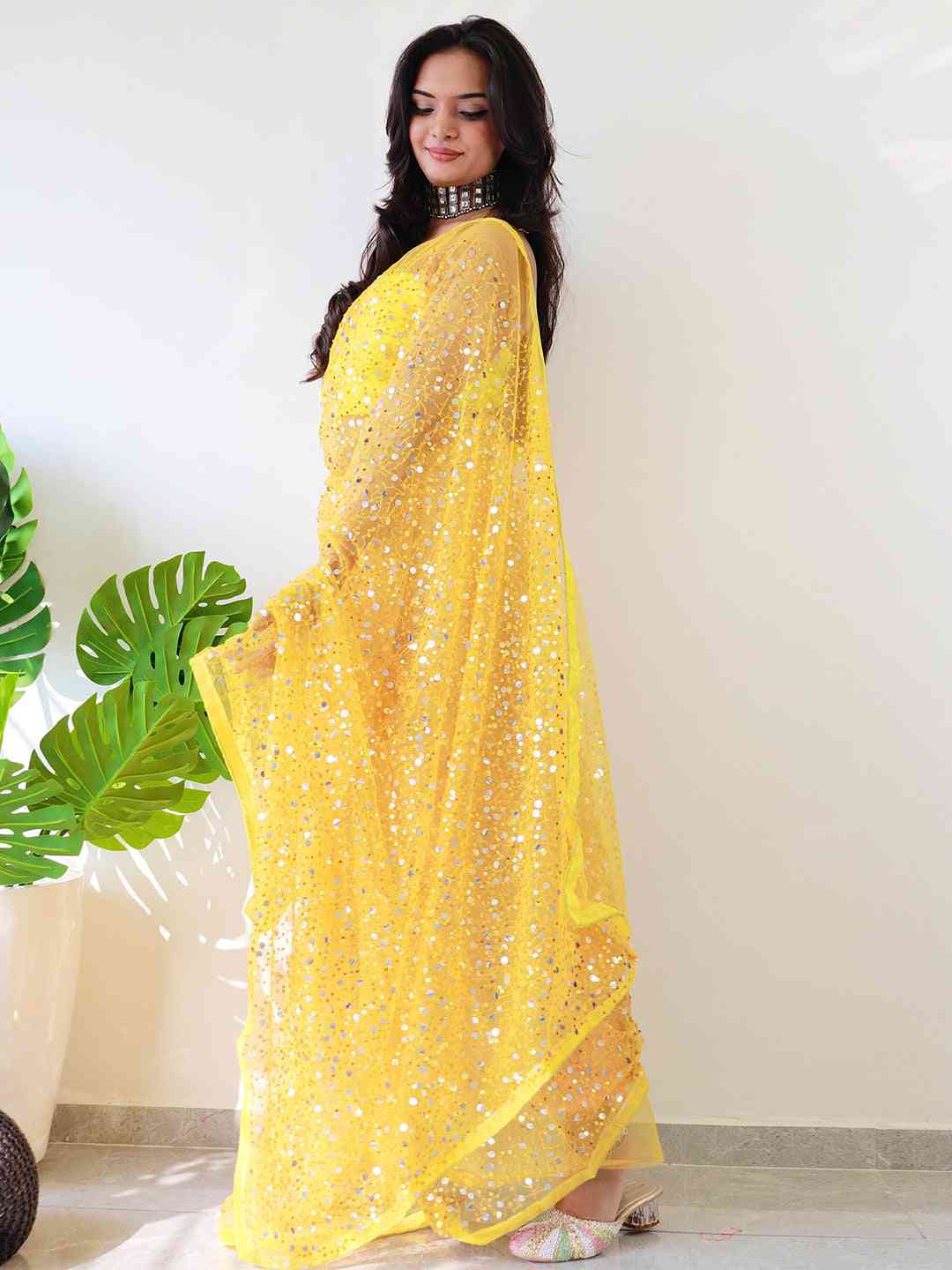 Back view of yellow sequined net saree on model