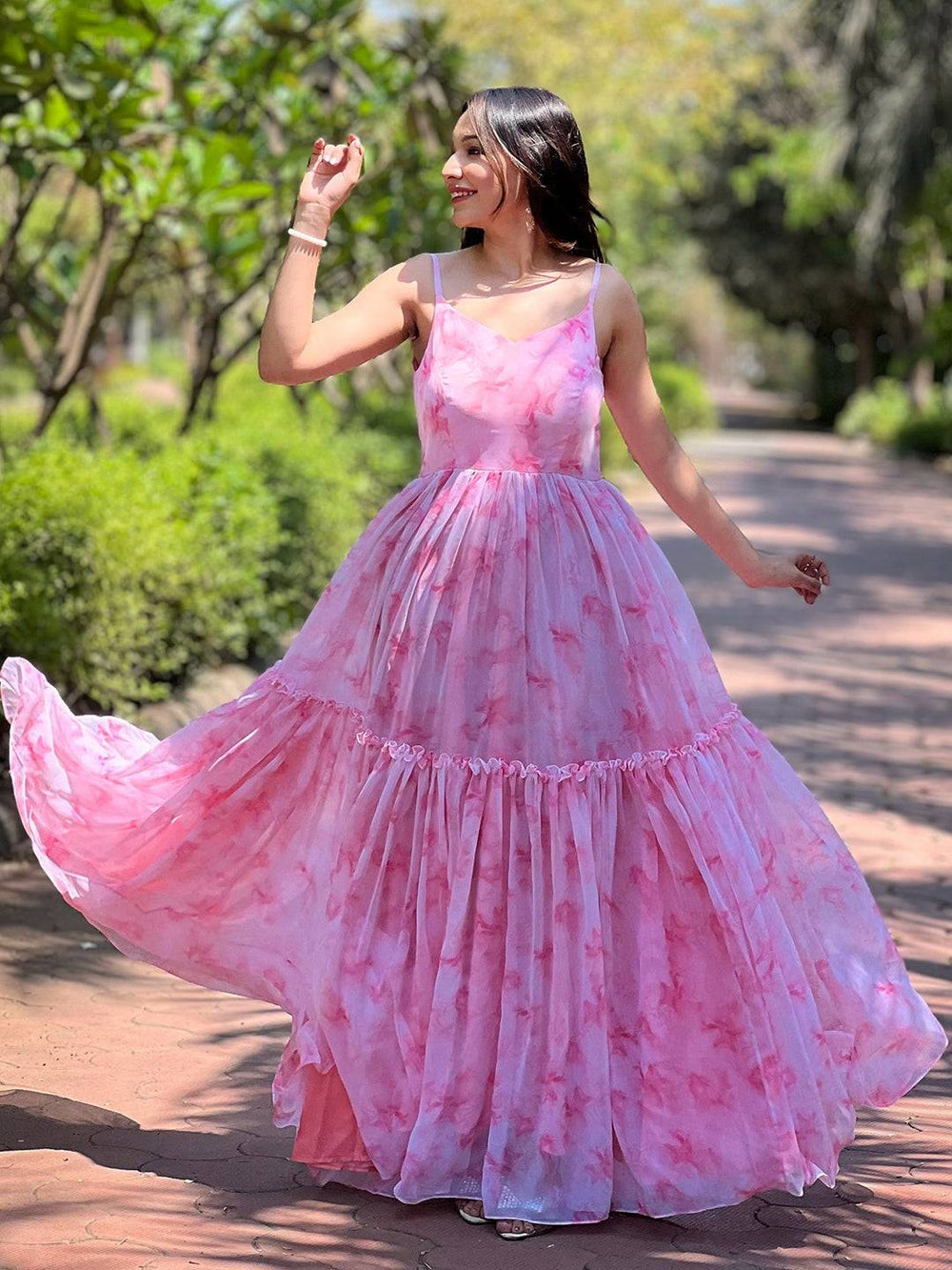Woman twirling in blush pink batik printed dress outdoors