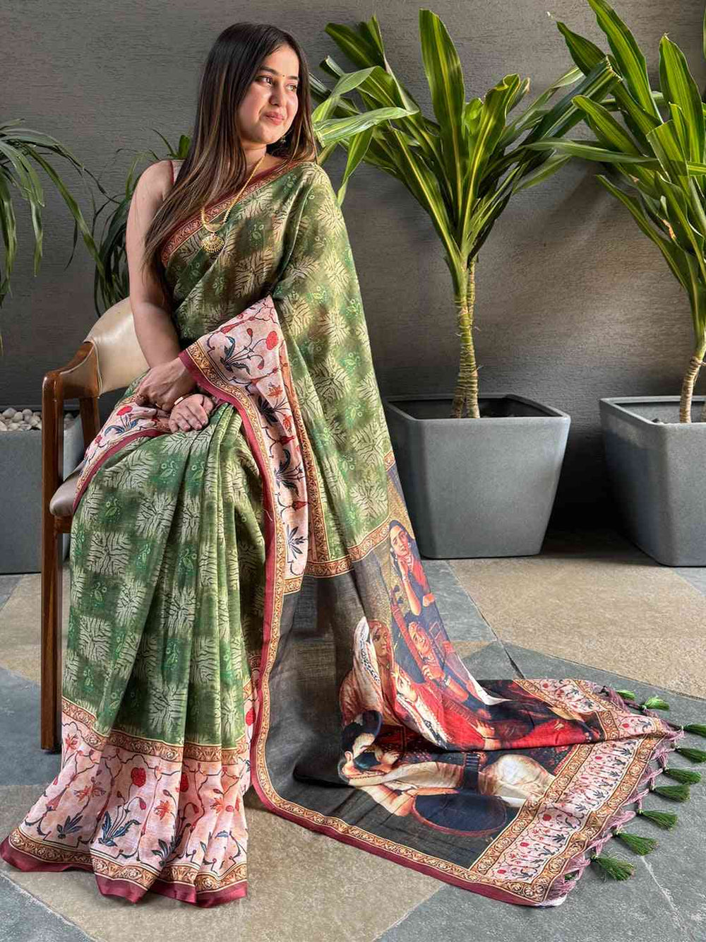 Model in green saree with kalamkari pallu, seated pose