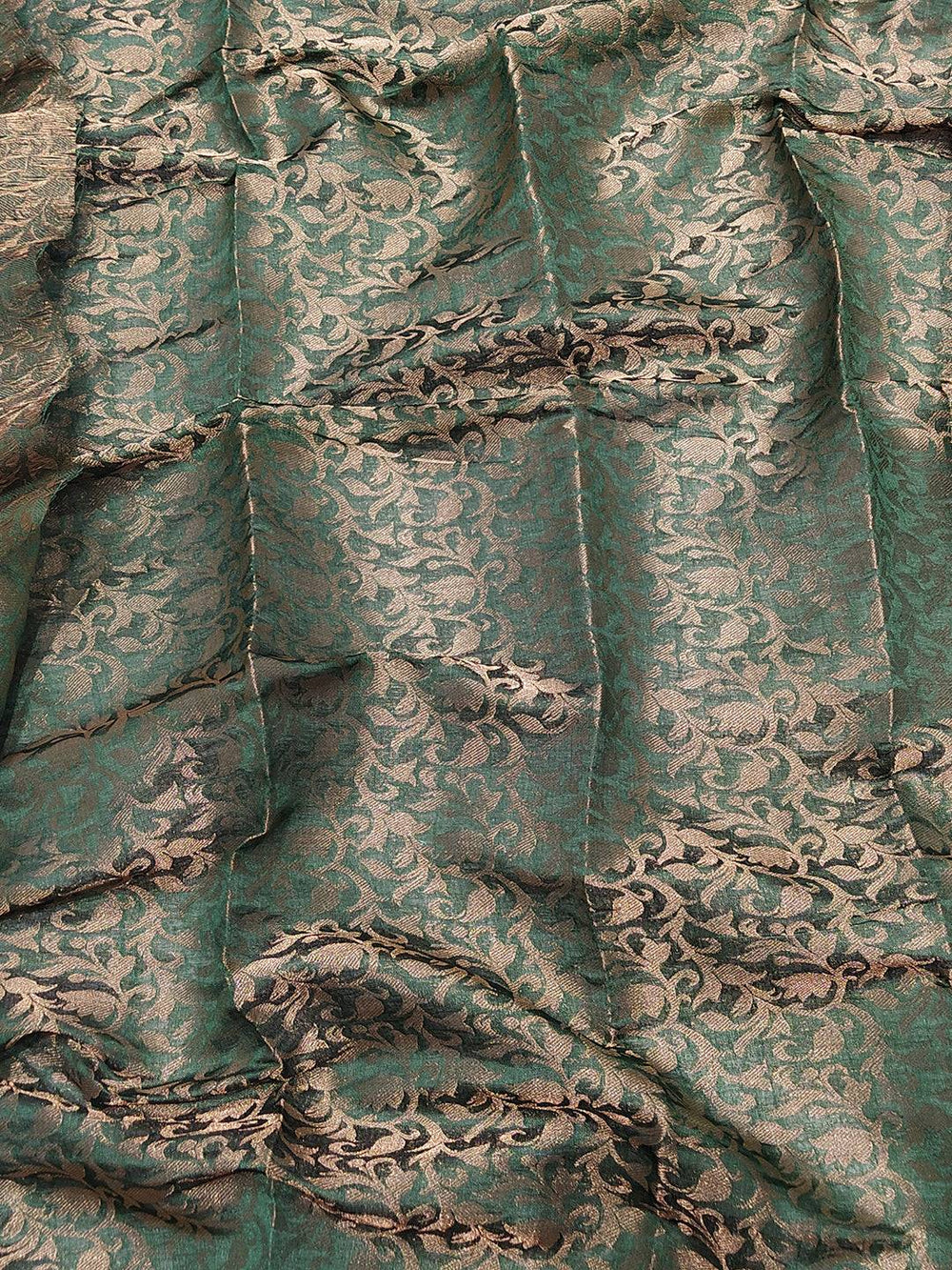 Close-up of green Kanjivaram saree fabric with floral patterns