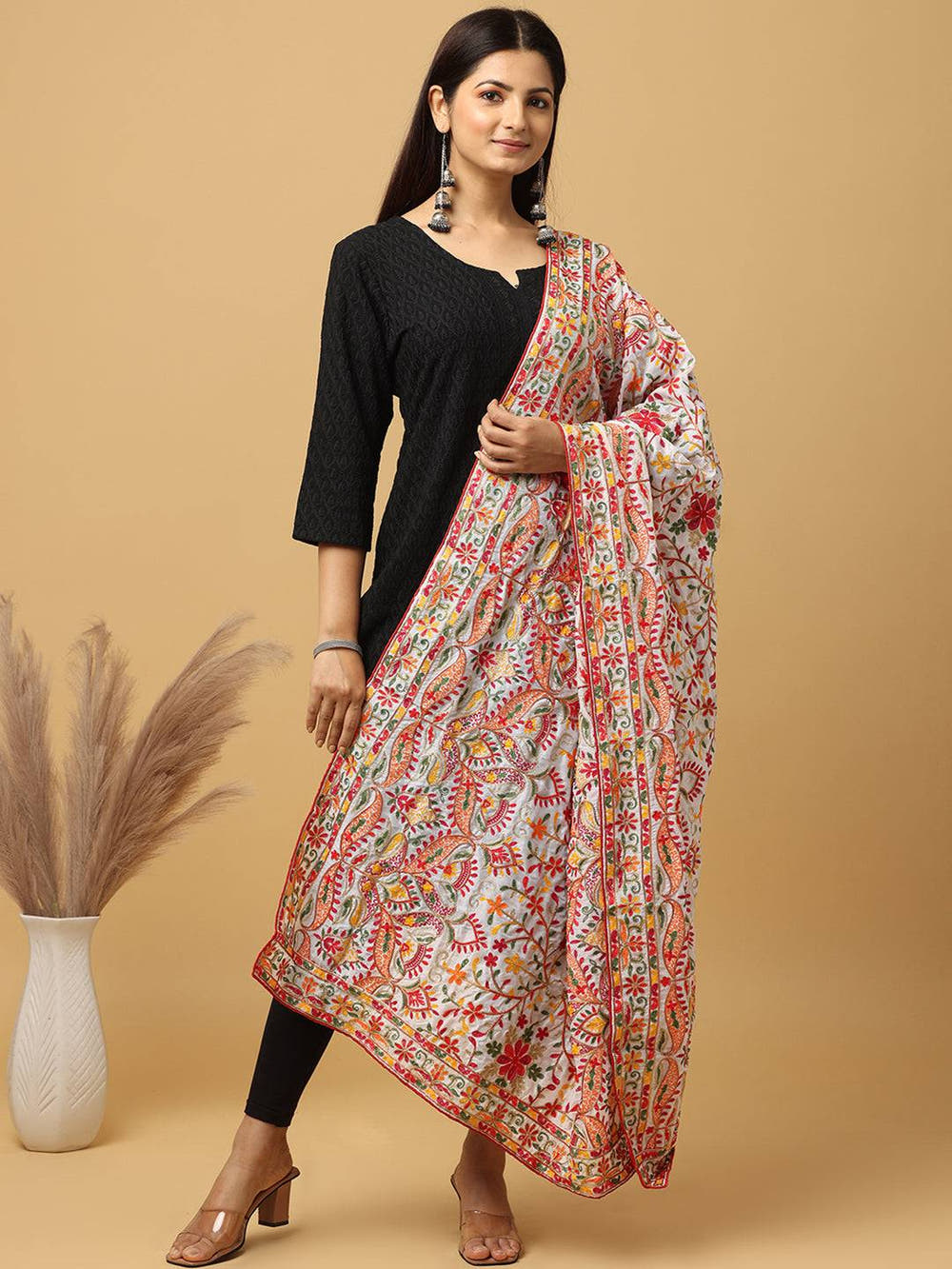 Model wearing white pashmina dupatta with vibrant embroidery.