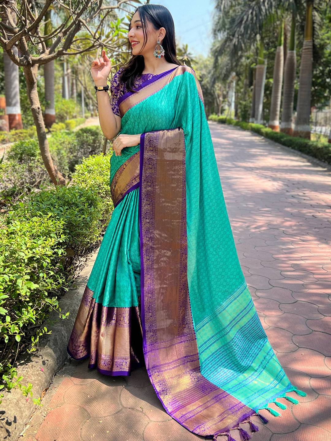 Elegant turquoise Kanjivaram saree with zari border in garden