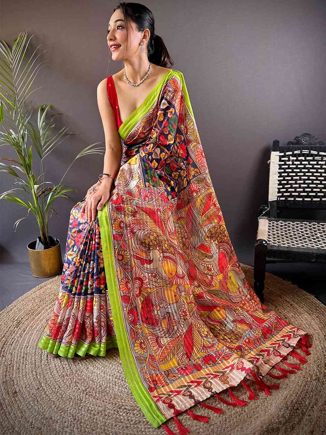 Model seated in Orchid Blue Pen Kalamkari Linen Saree showcasing details