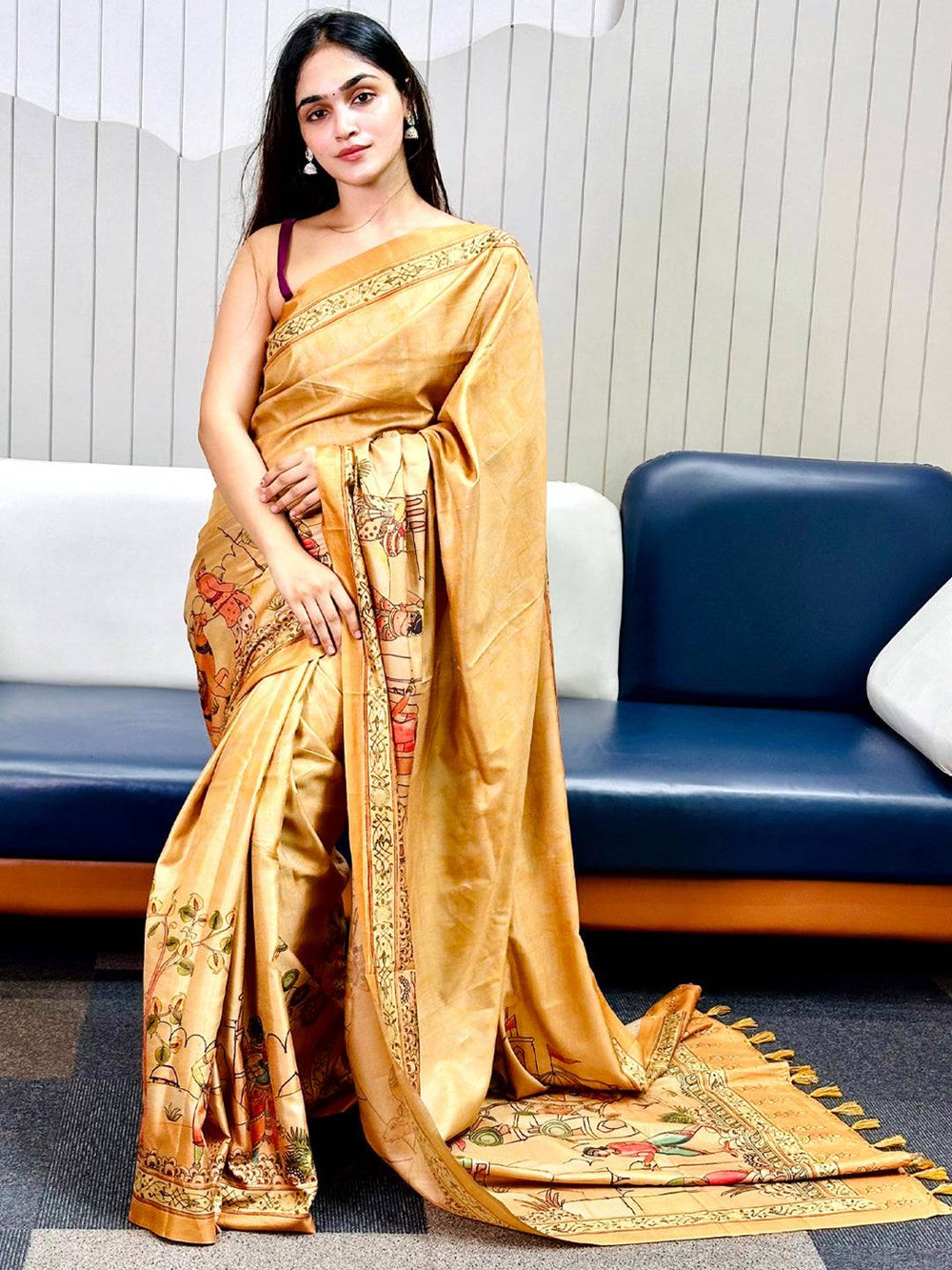 Elegant gold Kalamkari saree featuring detailed artwork, modeled gracefully.
