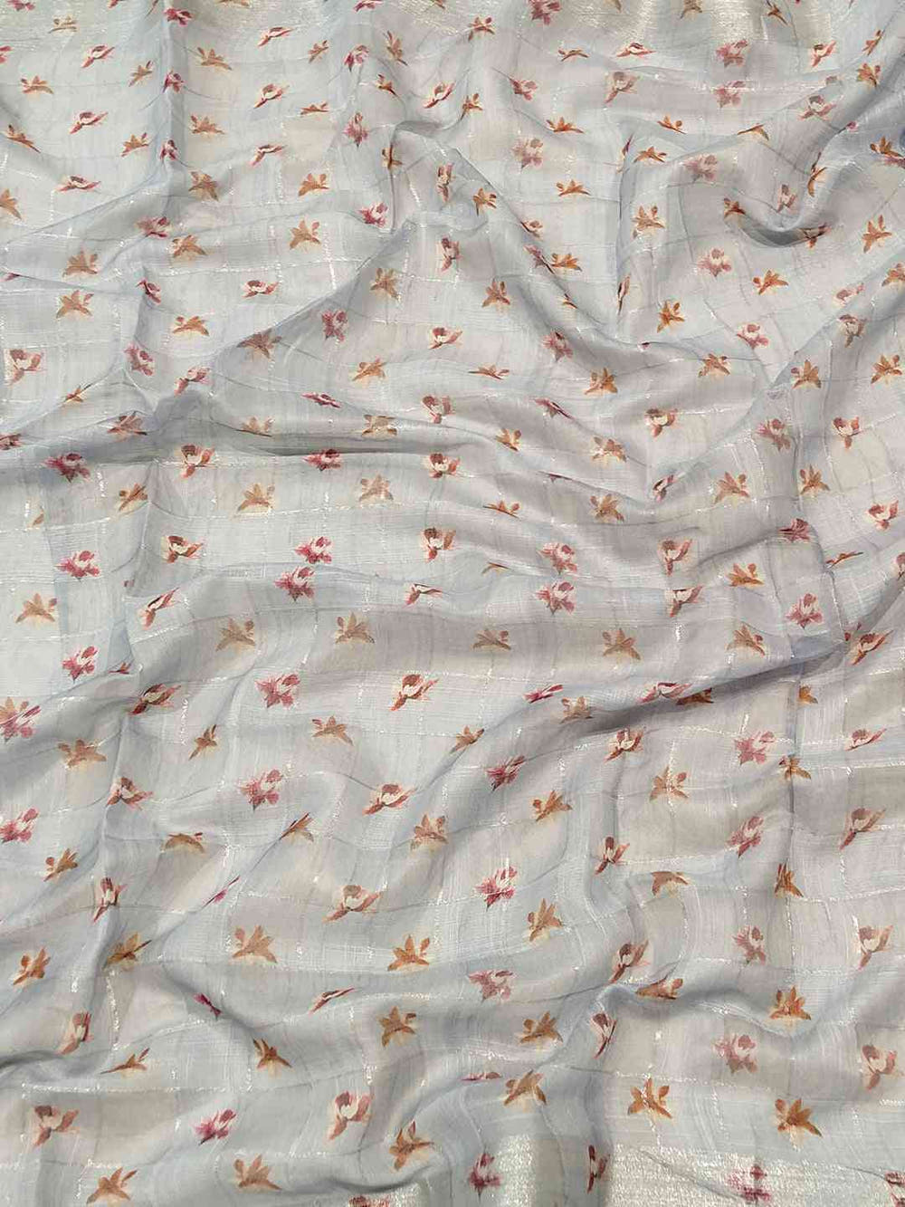 Close-up of blue saree fabric with floral and zari chex pattern.
