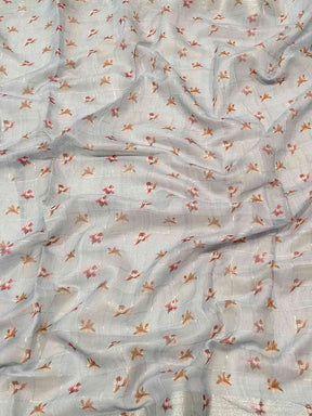 Close-up of blue saree fabric with floral and zari chex pattern.