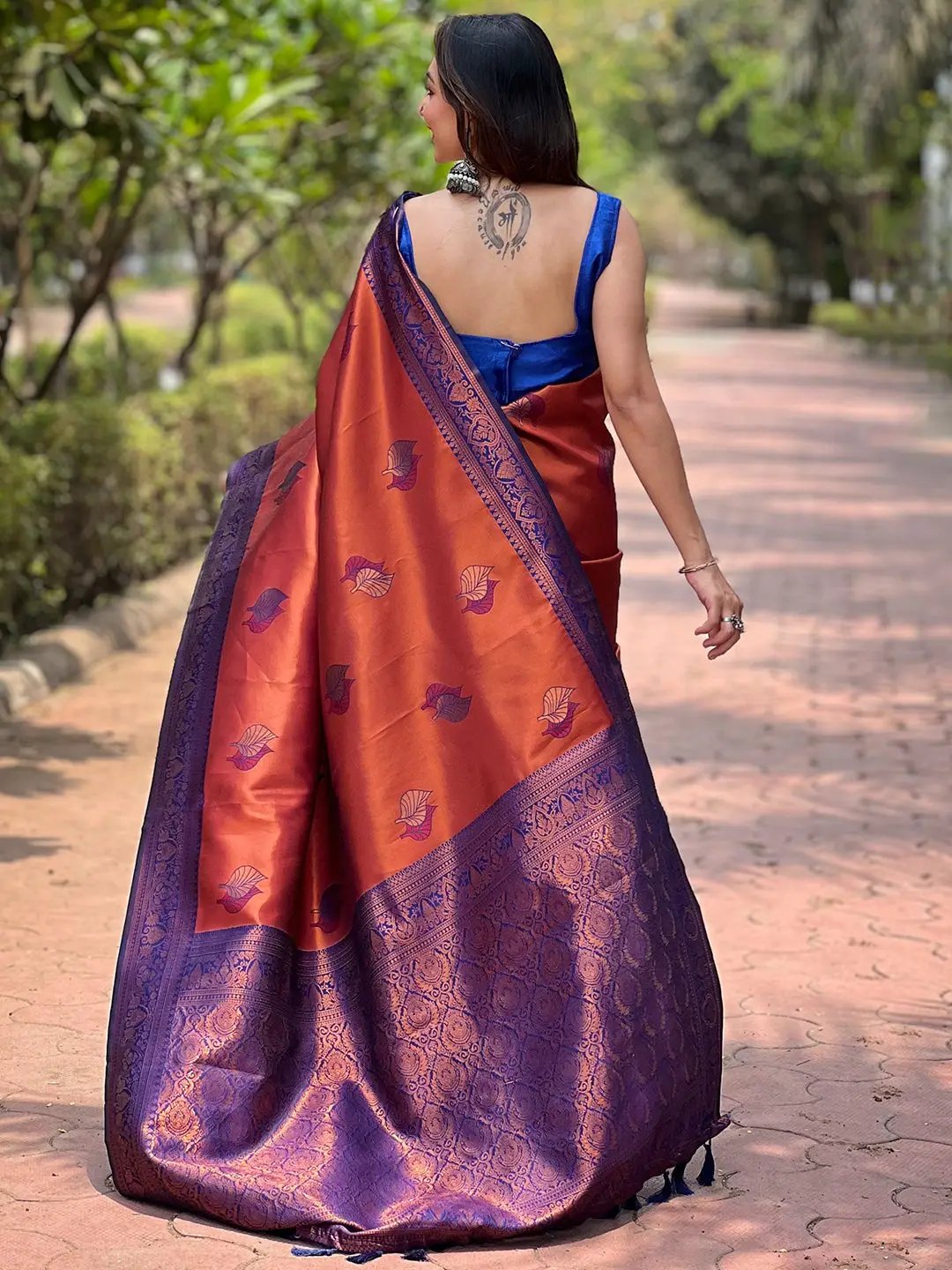 Back view of rust red Kanjivaram saree with gold zari details.