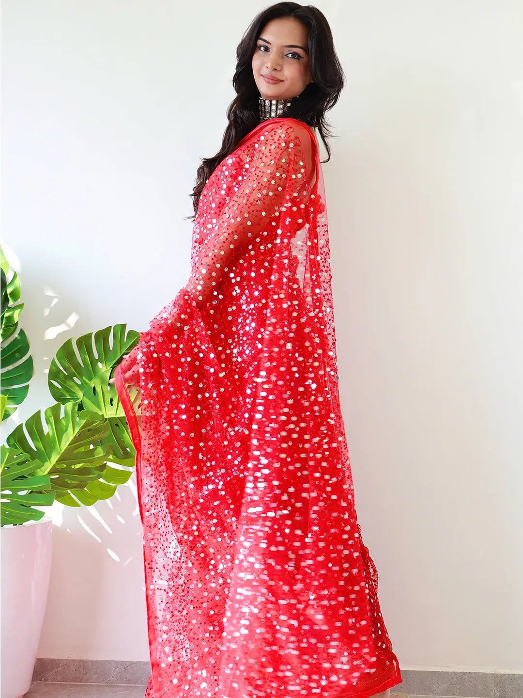 Side view of red net saree with sequins embroidery.