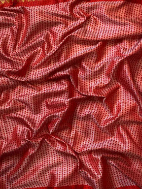 Close-up of red Bandhej print on soft silk fabric