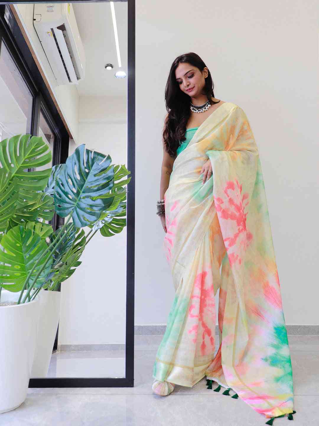 Woman wearing colorful tie dye saree with green and pink hues