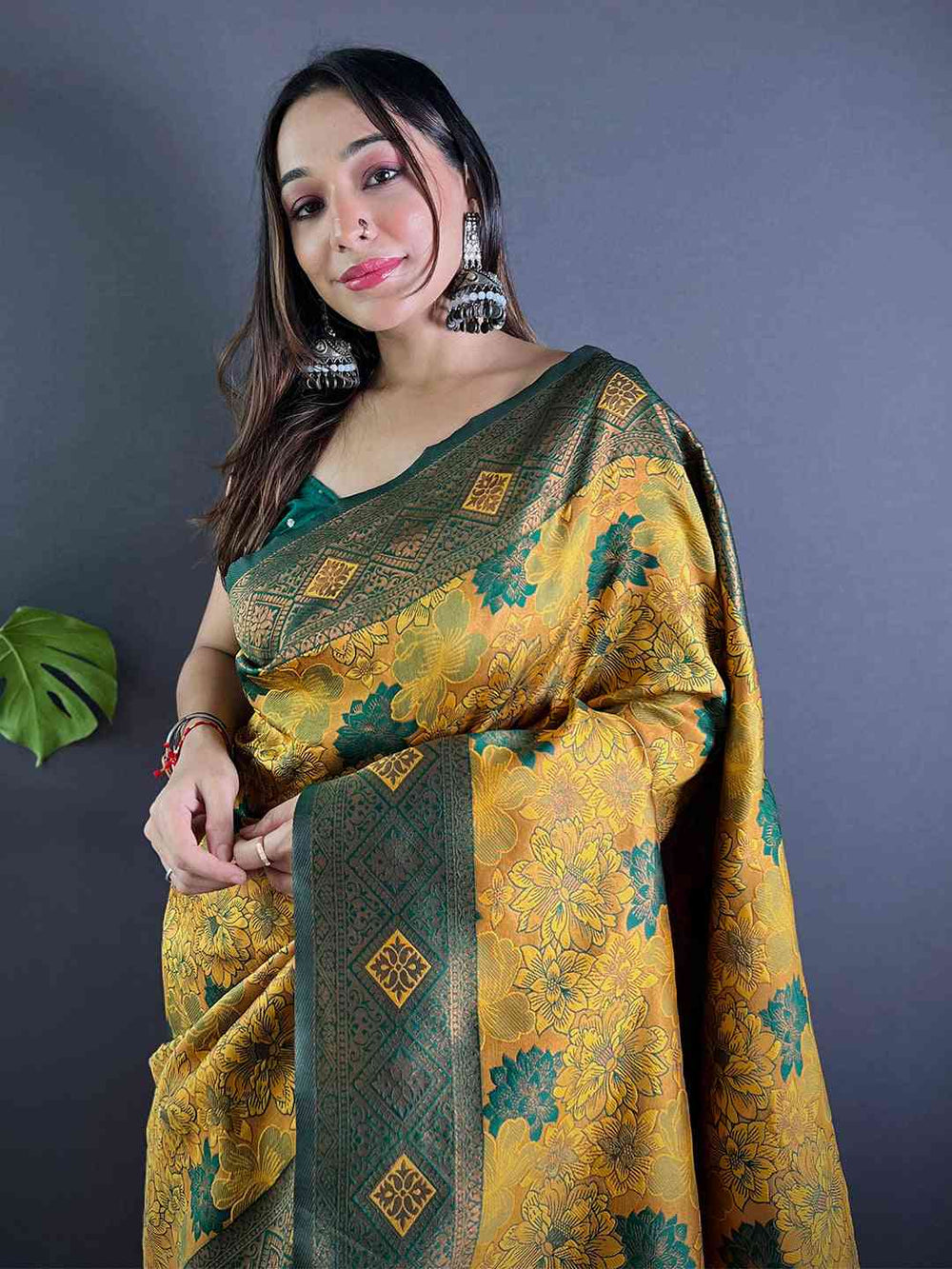 Mustard silk saree with floral butta weaving, worn by model.