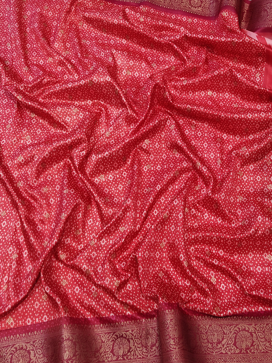 Close-up of red Banarasi saree fabric with detailed patterns