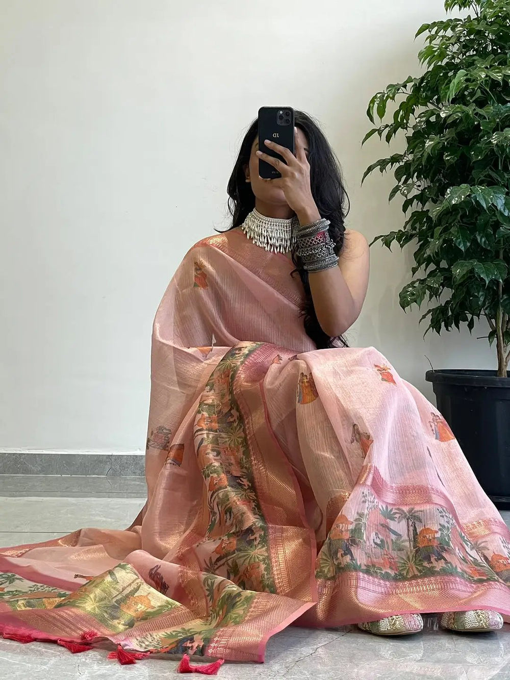 Elegant soft gold zari tissue saree with digital print, model seated.