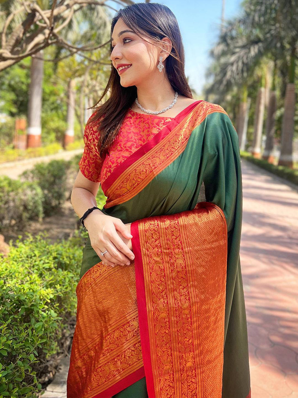 Woman in bottle green Kanjivaram saree with red blouse outdoors