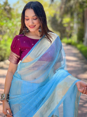 Blue organza saree with gold zari border, worn by a model