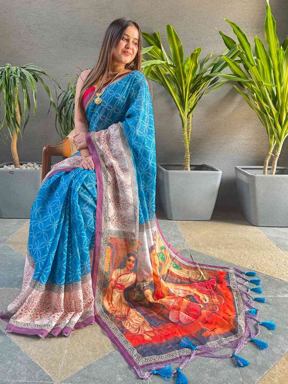 Seated model in blue saree with vibrant kalamkari print