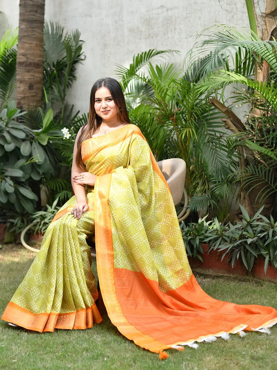 Lime soft silk Bandhej saree with orange border, garden setting