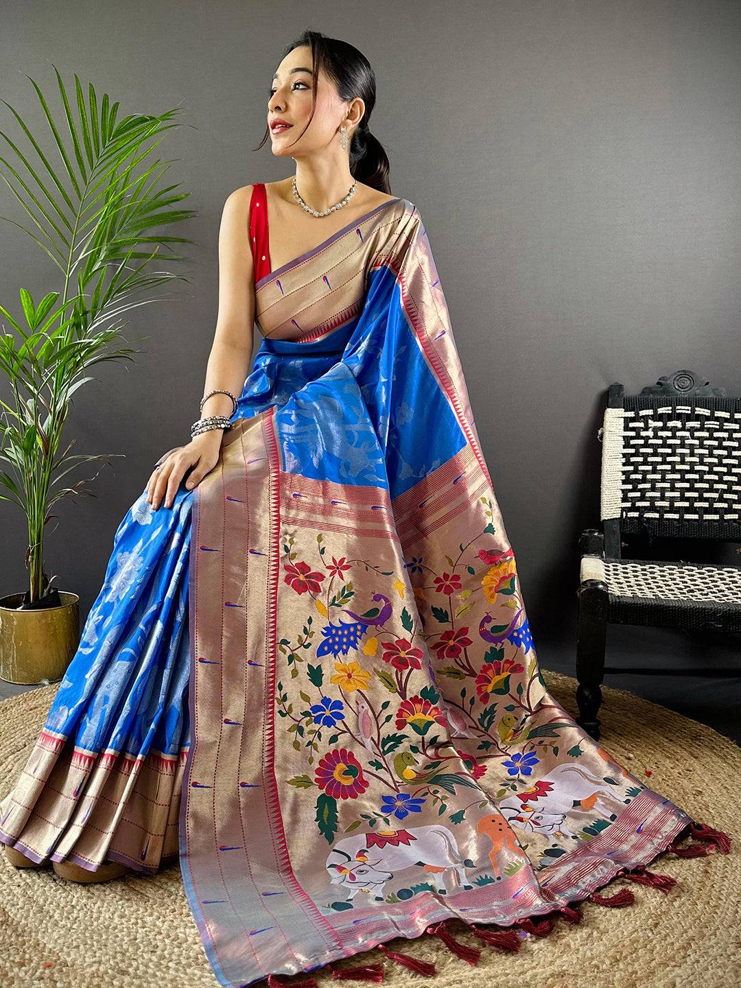 Seated model in Royal Blue Paithani Silk Saree with colorful Pichwai design.