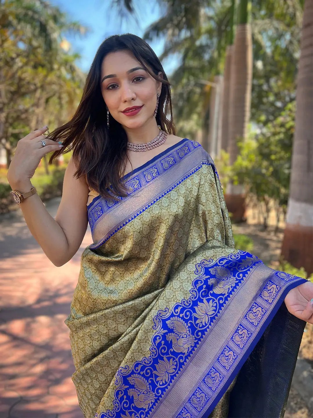 Model wearing olive Kanjivaram saree with blue accents