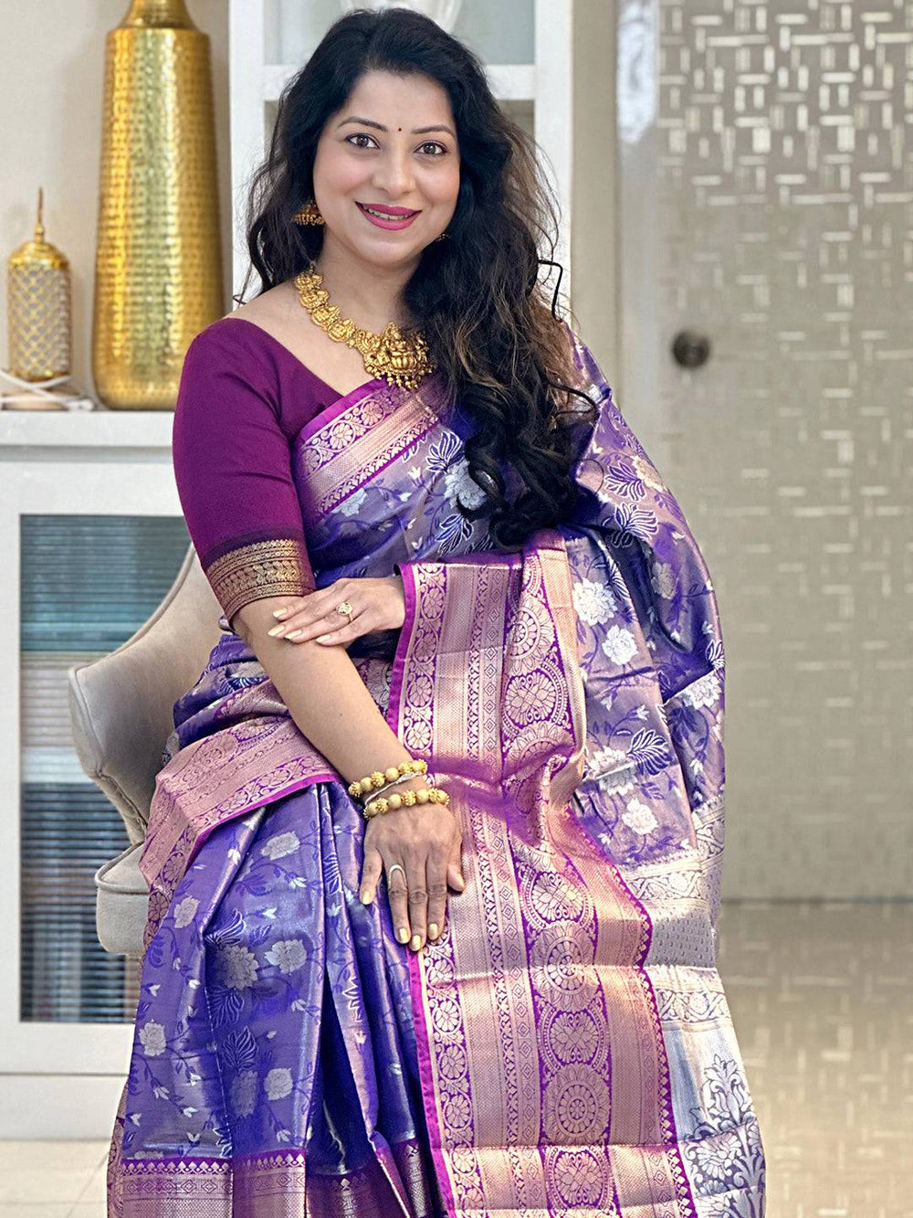 Woman in purple tissue silk saree seated indoors Vastranand 