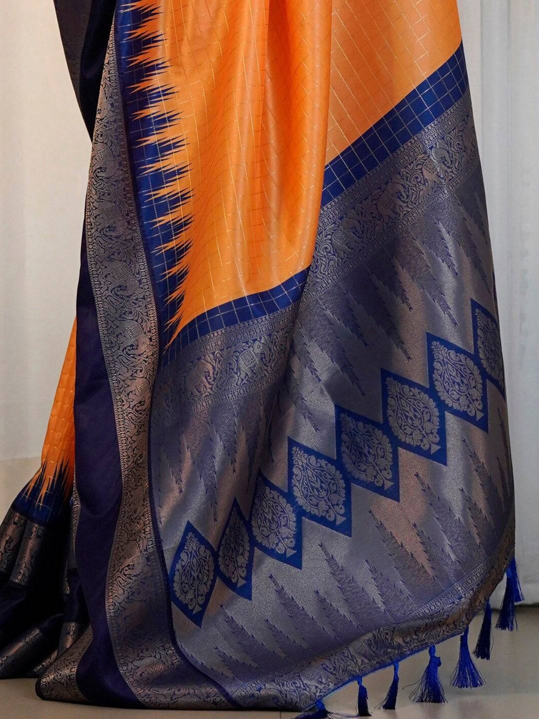 Detailed view of orange saree with blue zari weaving.