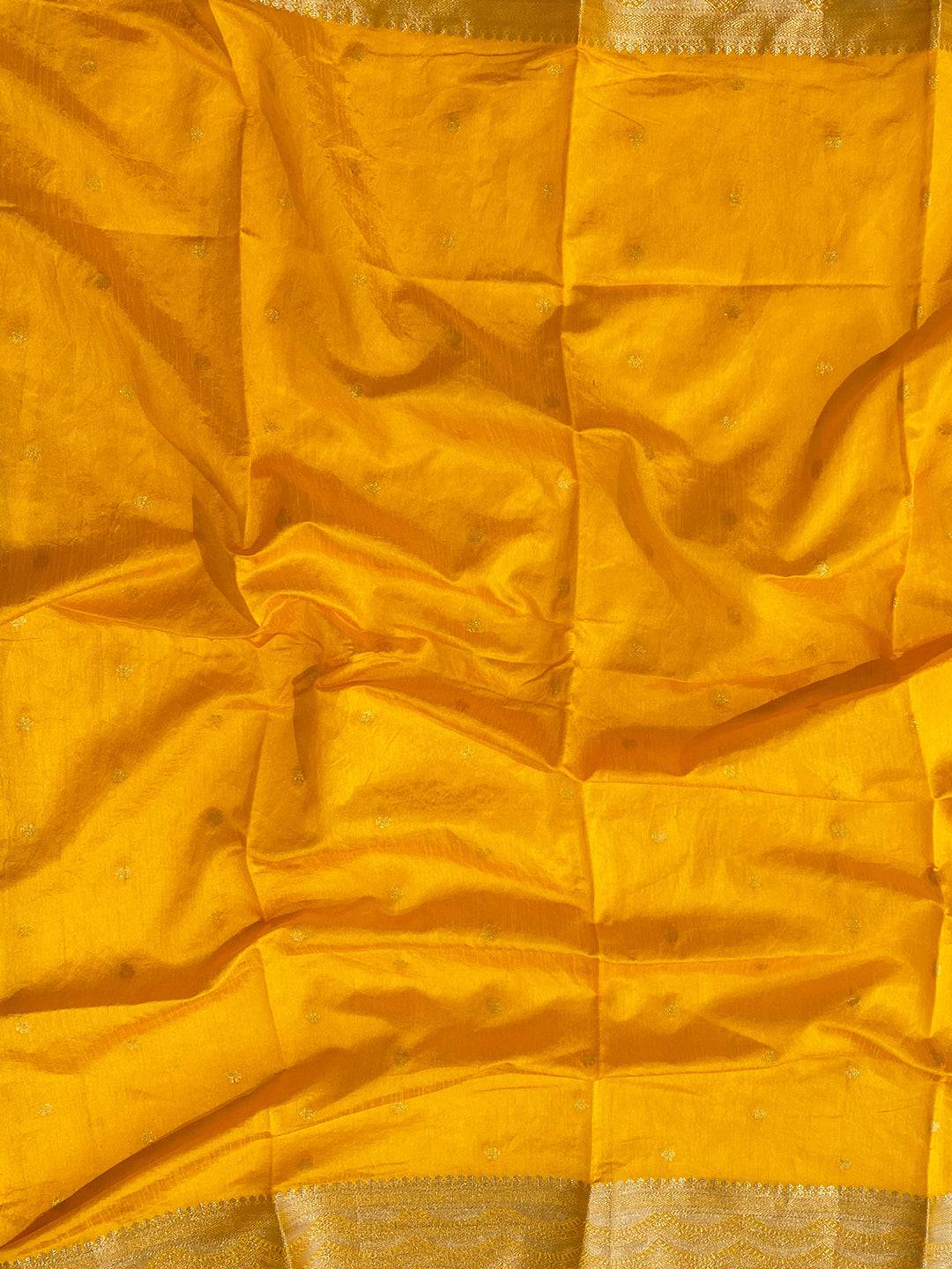 Close-up of yellow fabric with gold zari border