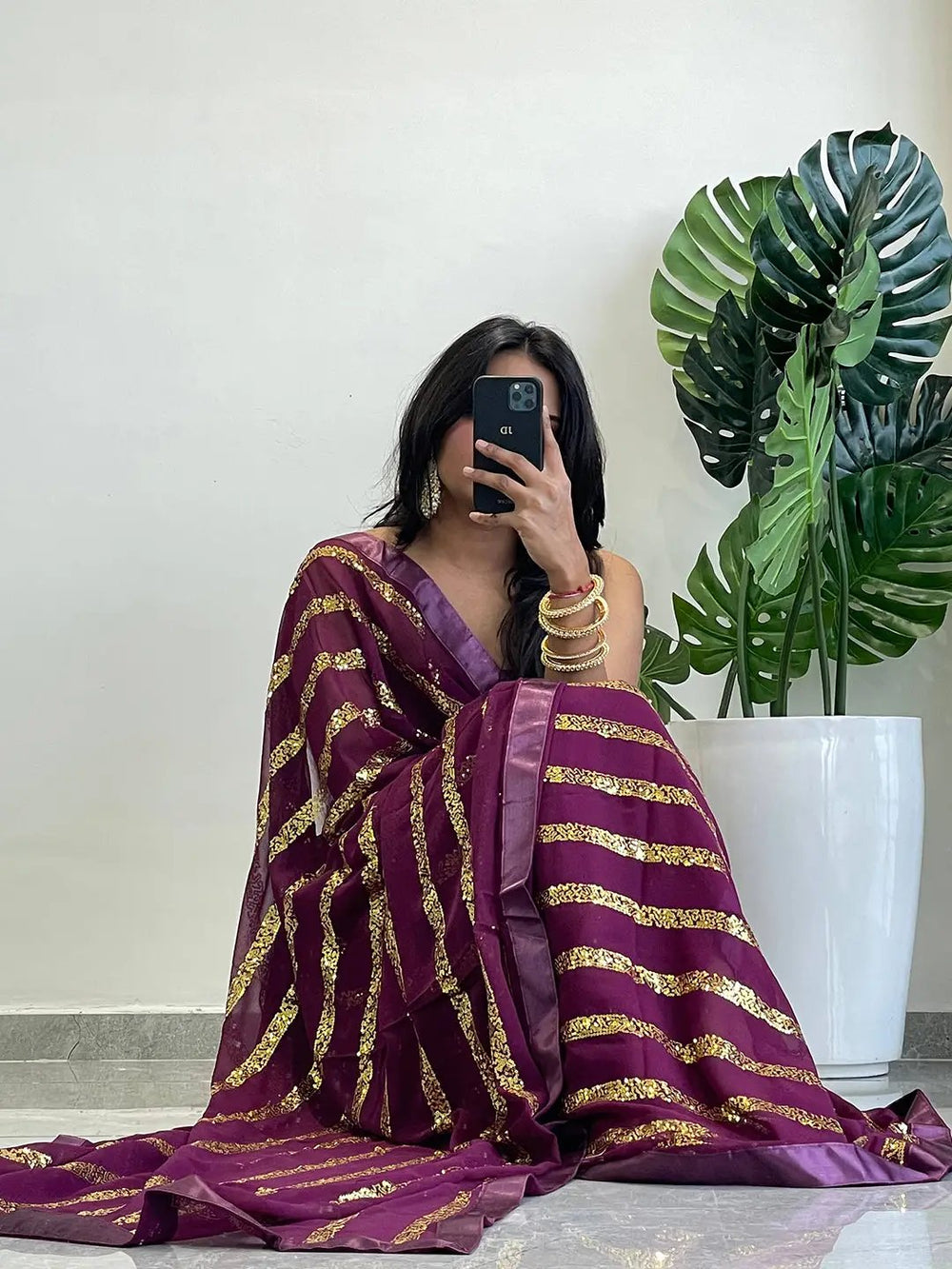 Seated pose with georgette saree featuring sequins stripes