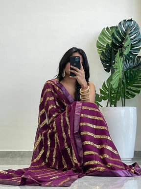 Seated pose with georgette saree featuring sequins stripes