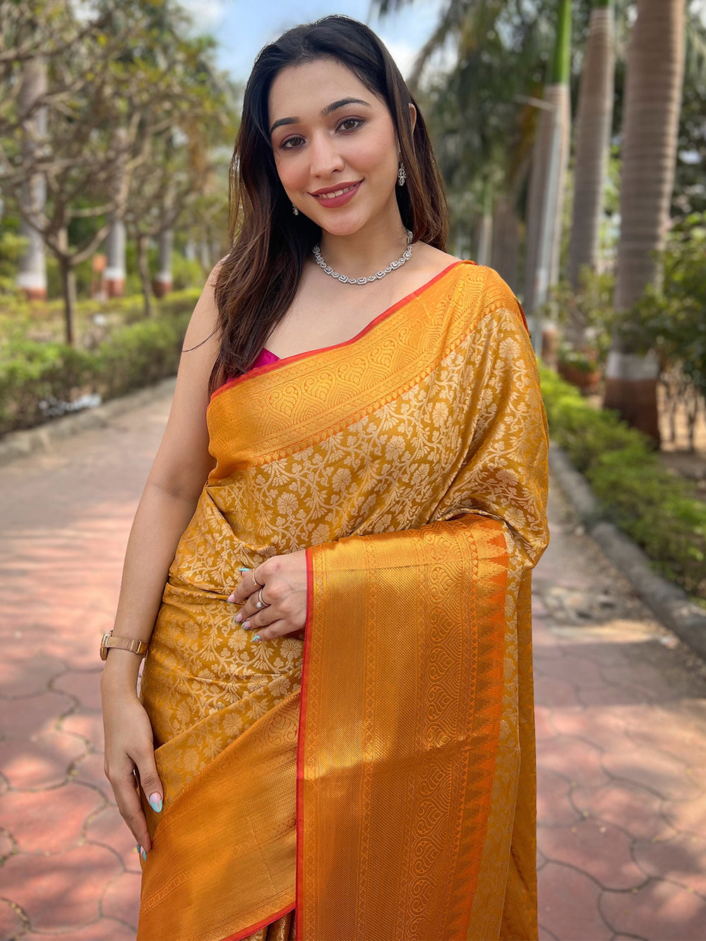 Model wearing yellow gold tissue saree with jacquard woven pattern