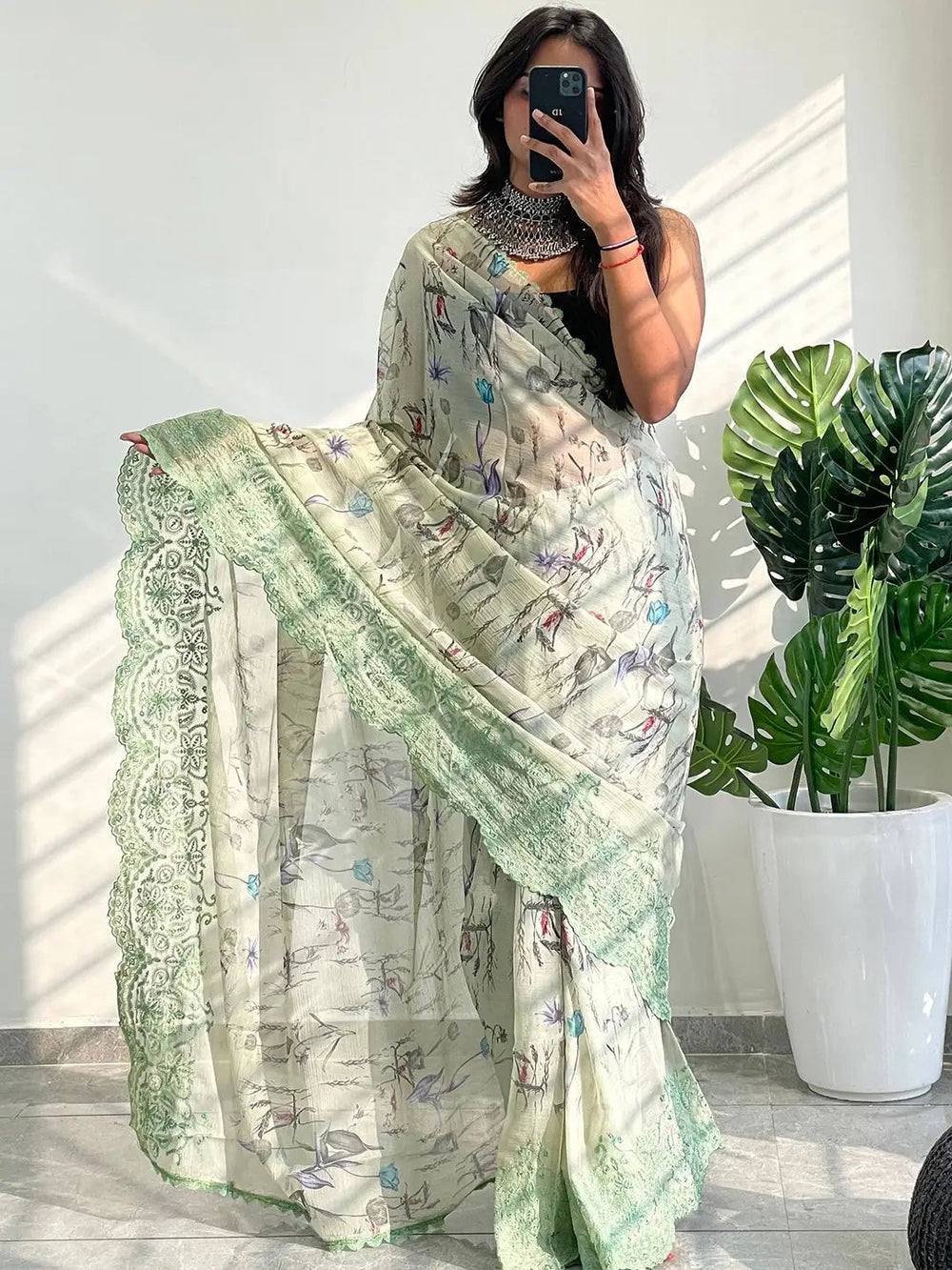 Stylish chiffon satin saree with floral motifs and green embroidered edge.