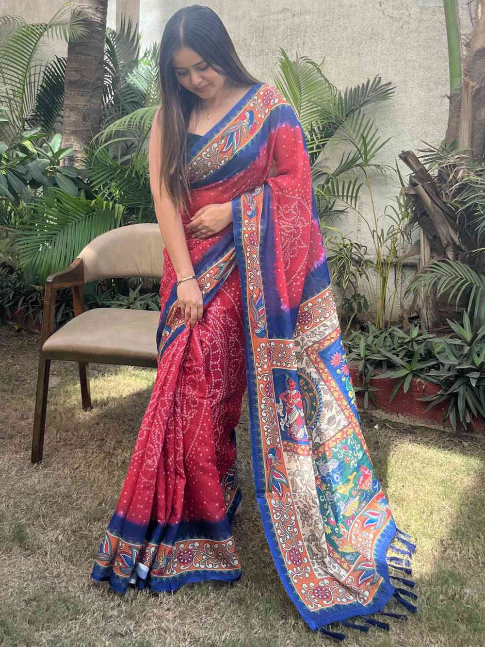 Red linen saree with Bandhej and kalamkari print, adjusting drape