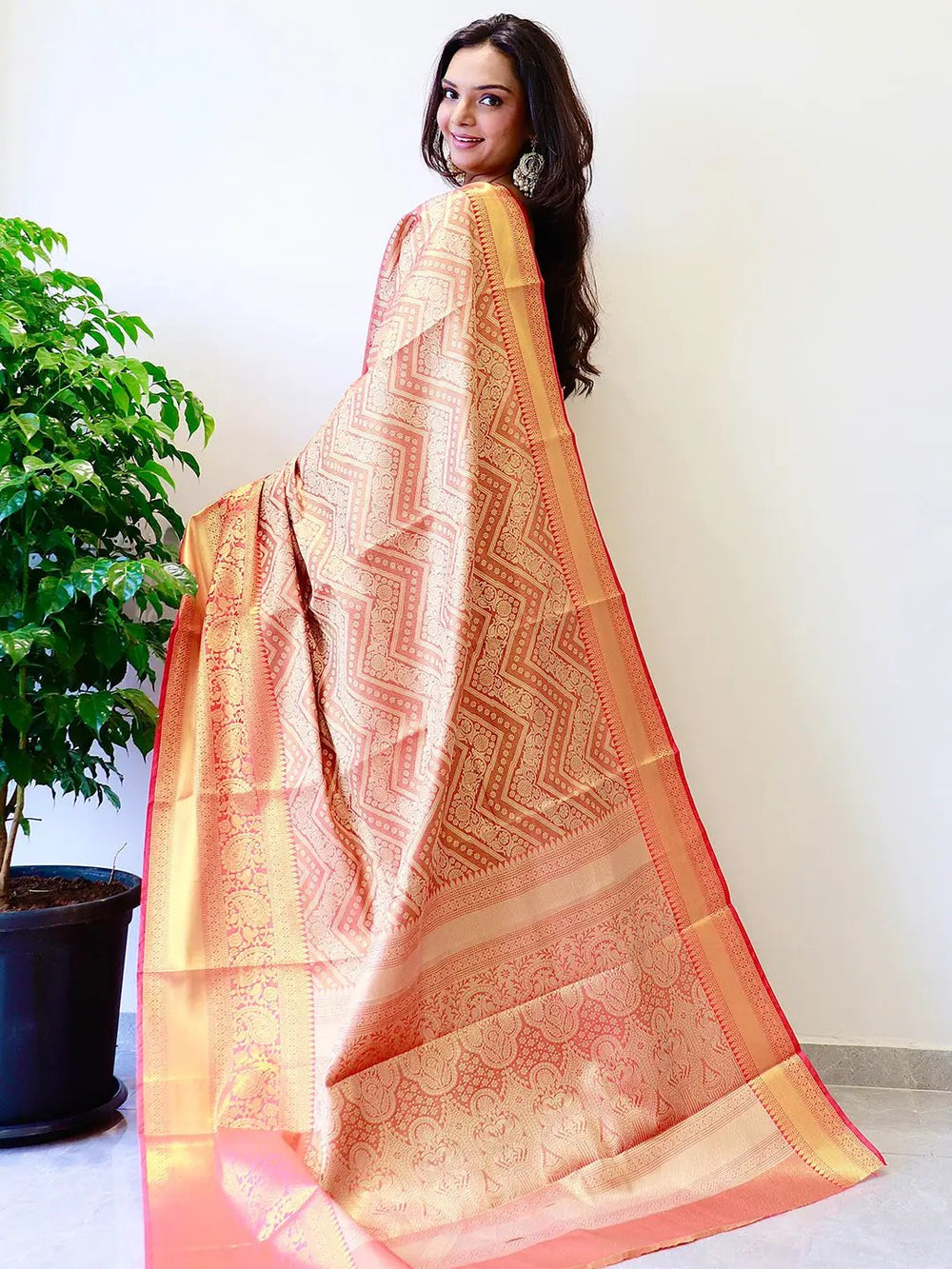 Back view of gold zari Kanjivaaram silk saree with intricate patterns.