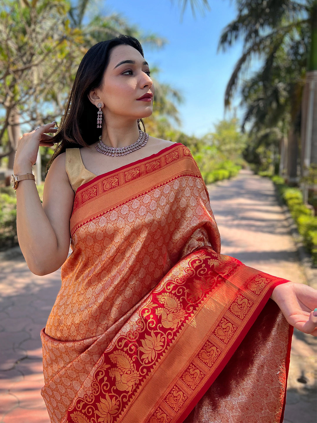Close-up of orange-red Kanjivaram saree with gold motifs