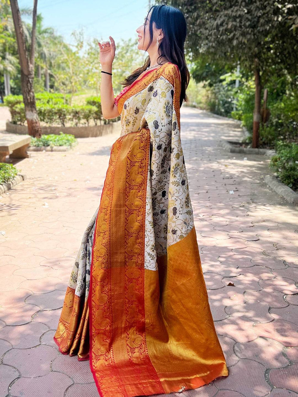 Side view of woman in red and gold Banarasi silk saree