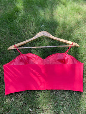 Back view of red sleeveless blouse on hanger