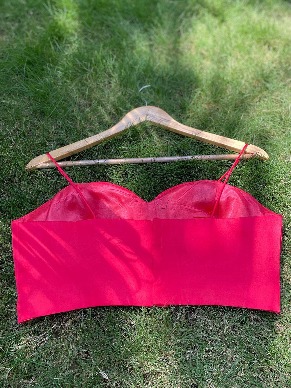 Back view of red sleeveless blouse on hanger