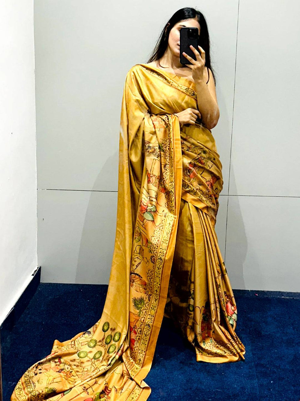 Gold Kalamkari print saree displayed in a mirror selfie, highlighting the design.