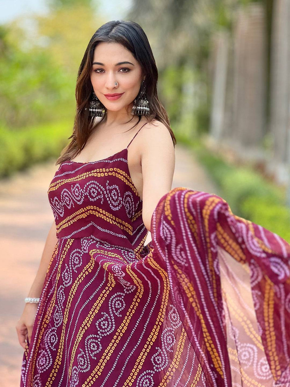 Woman holding Wine Bandhej Printed Dress fabric outdoors