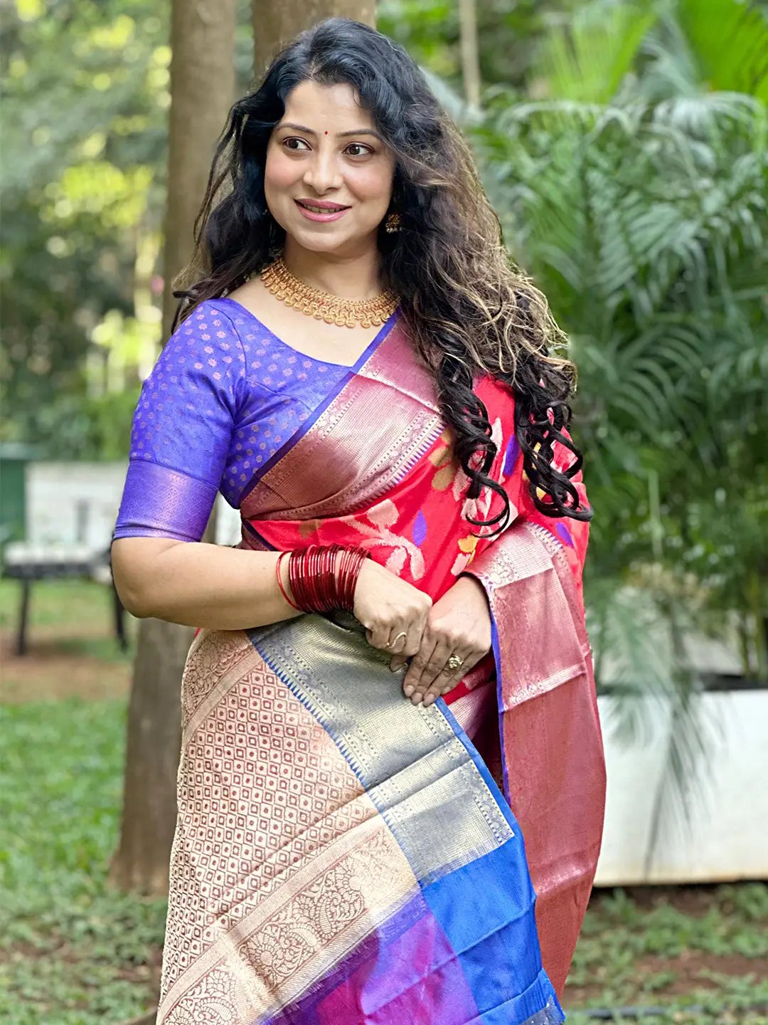 Woman in red Banarasi saree with Minakari Ikkat design