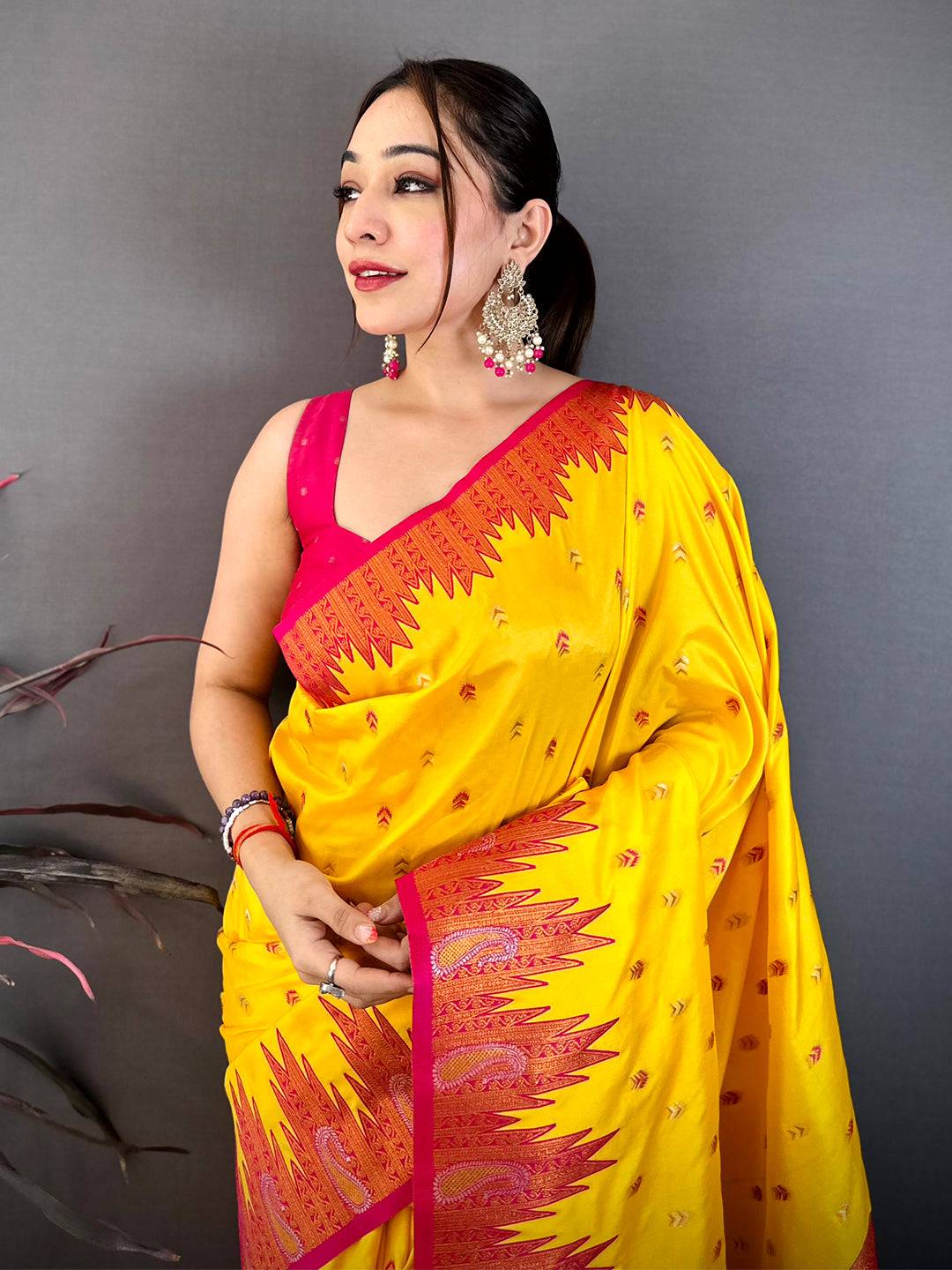 Yellow silk saree with pink border and intricate zari design