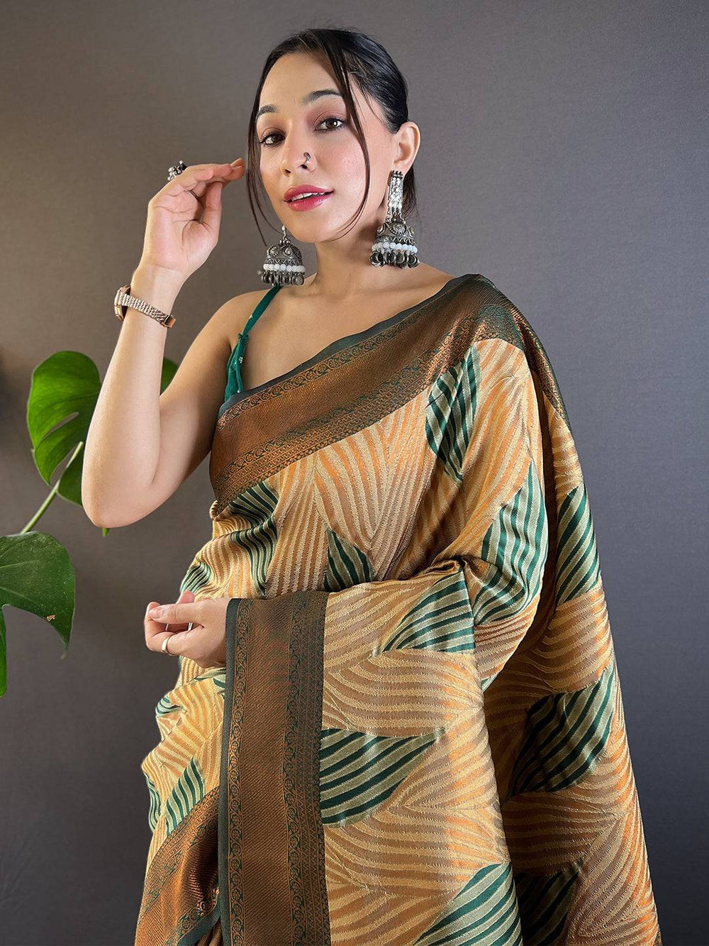 Model wearing brown Tussar silk Ikkat saree with green patterns.