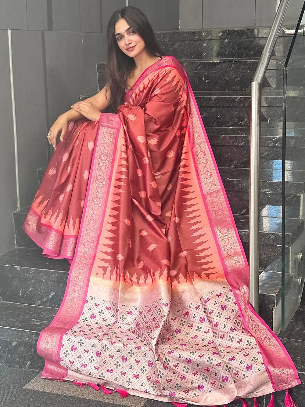 Soft silk Banarasi saree with intricate zari patola pallu on stairs.