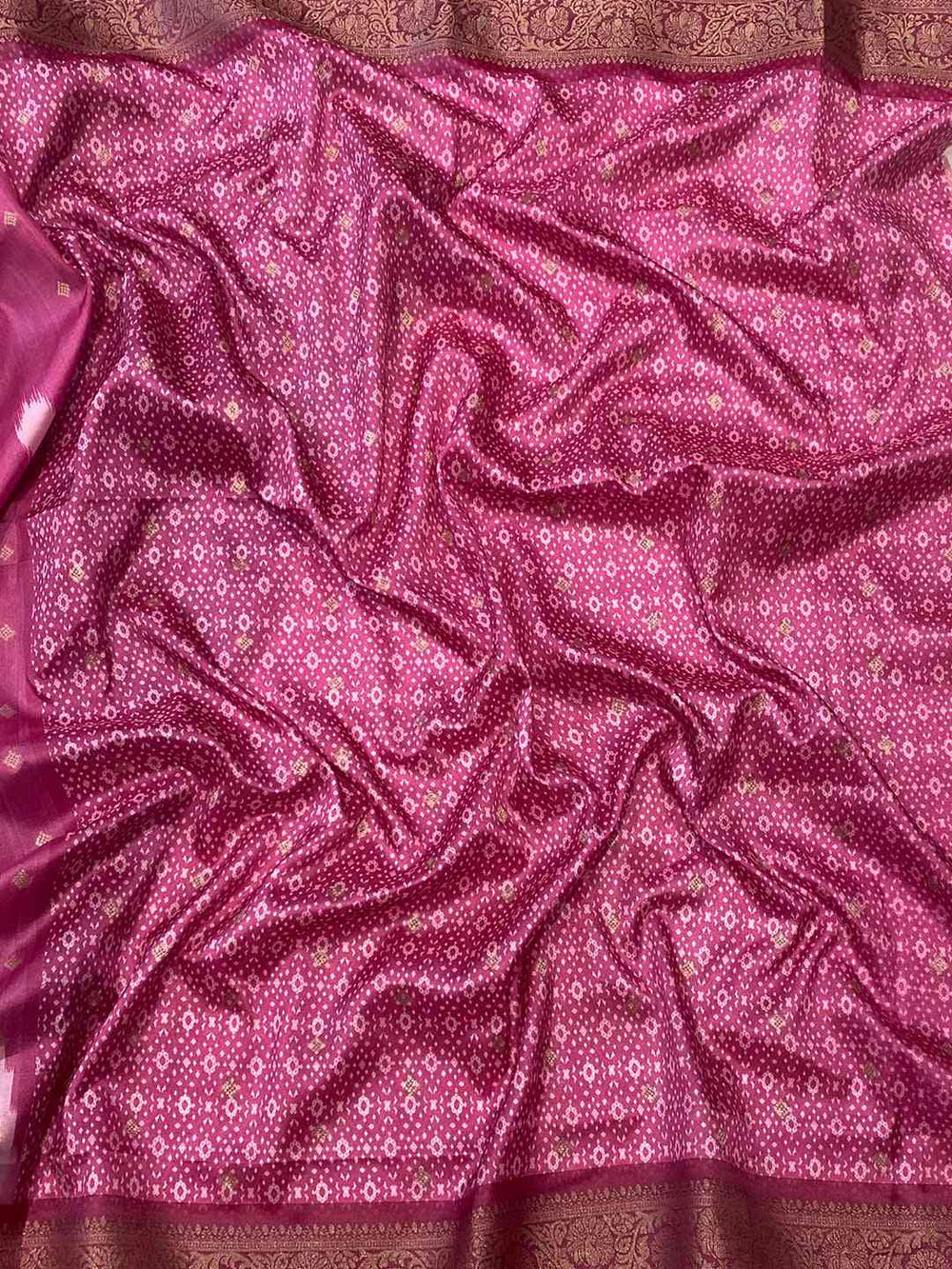 Close-up of pink Banarasi saree fabric with intricate patterns