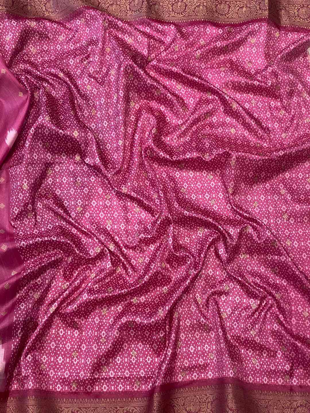 Close-up of pink Banarasi saree fabric with intricate patterns