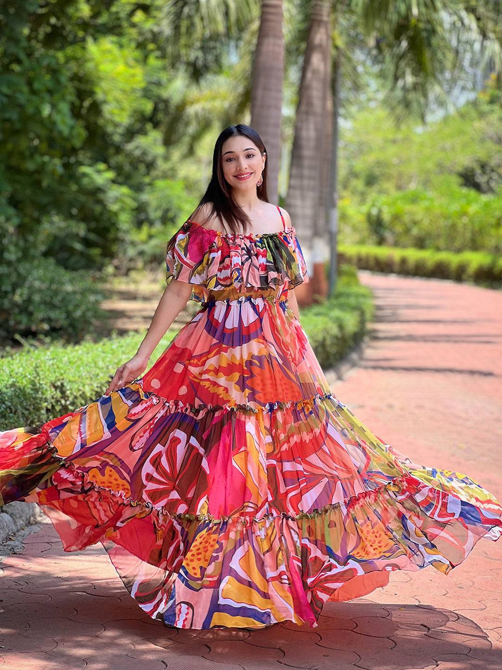 Model twirling in colorful off-shoulder maxi dress