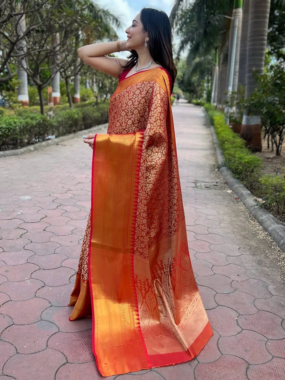 Side view of orange gold tissue saree with intricate jacquard design.